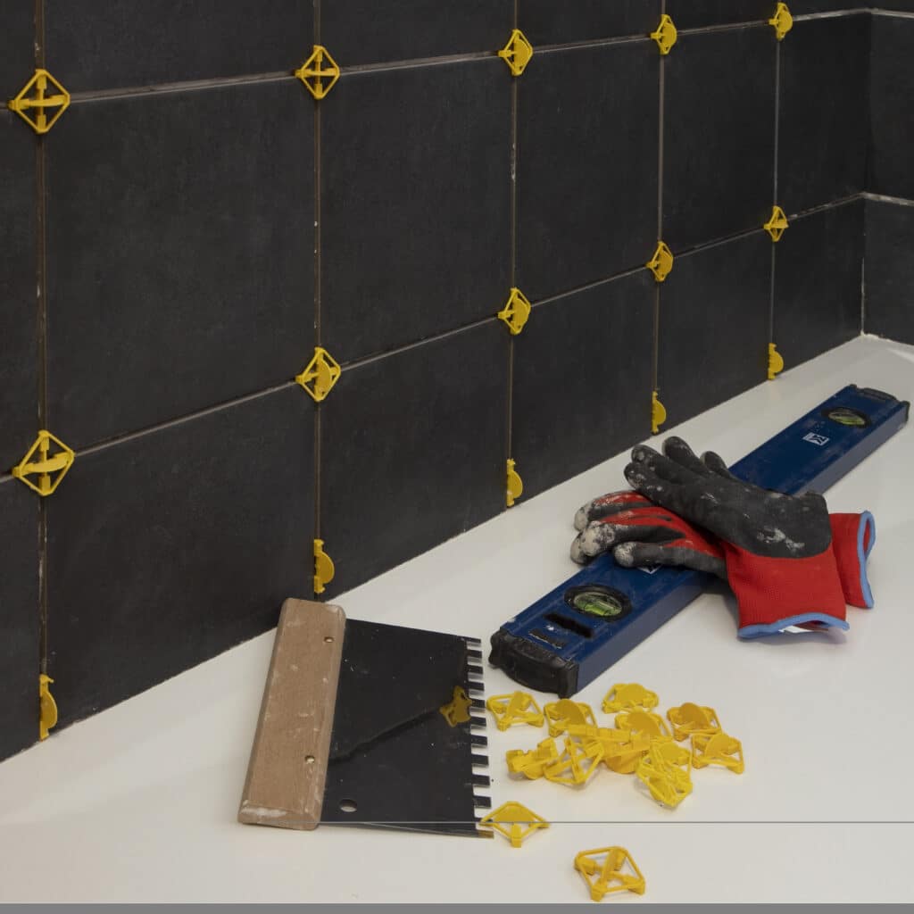 Pose d'un carrelage mural noir dans une salle de bains